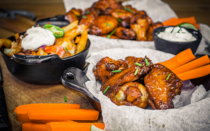 Курячі крила на рожні розкладені по тарілках