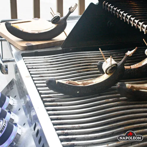 Банановий човен з морозивом і фруктами смажена на грилі